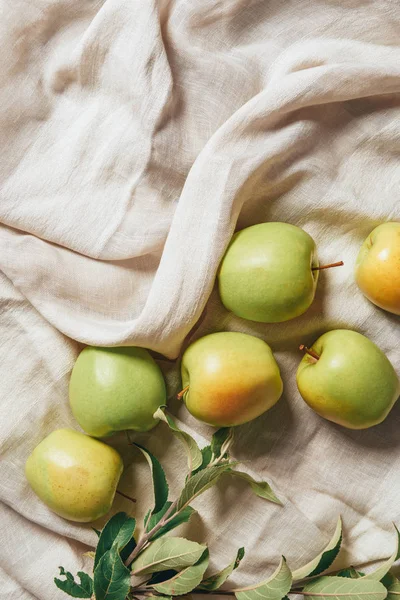 Top view of green apples with apple tree leaves on sacking cloth — Stock Photo