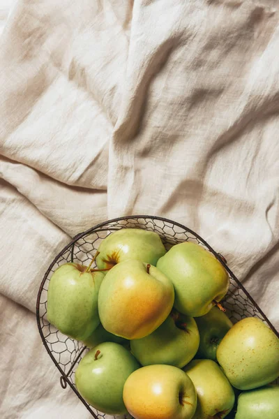 Top view of green apples in metal basket on sacking cloth — Stock Photo