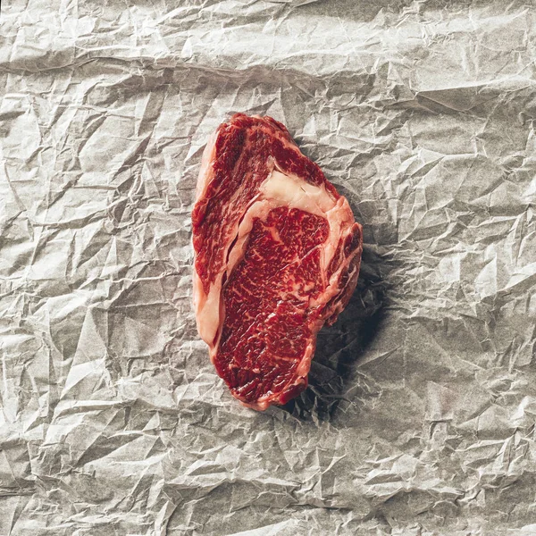 Vista superior del filete de carne cruda sobre papel de hornear en la cocina — Stock Photo