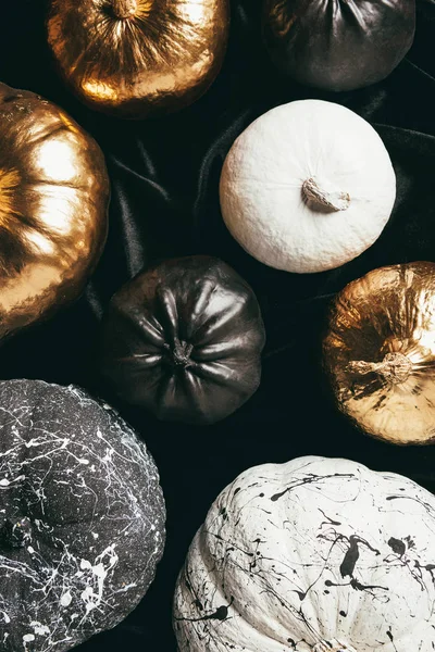 Vista superior de las tradicionales calabazas pintadas de oro, blanco y negro para fiesta de halloween - foto de stock
