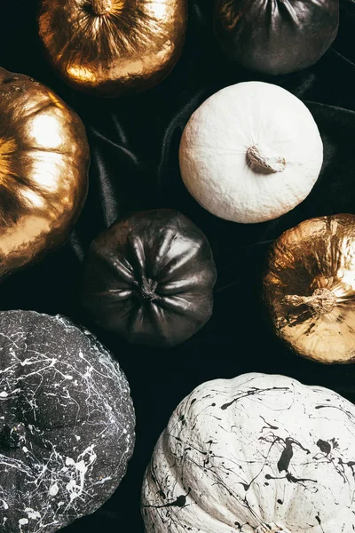 Vue de dessus des citrouilles peintes traditionnelles dorées, noires et blanches pour la fête d'Halloween — Photo de stock