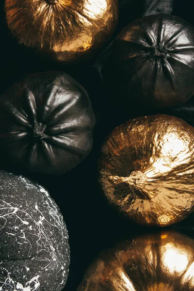 Top view of black and golden pumpkins on dark background, decoration for halloween — Stock Photo