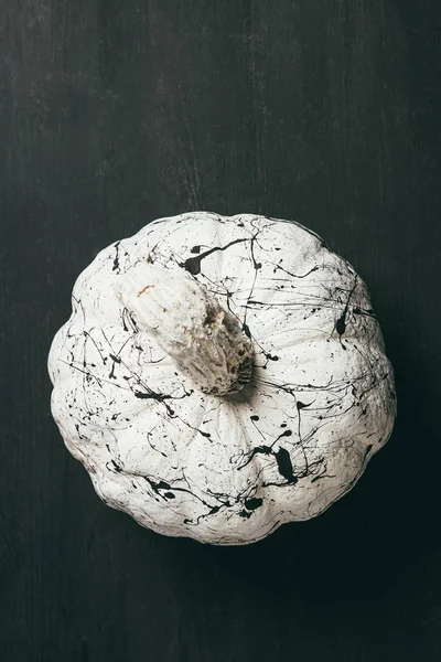 Top view of white pumpkin with black paint splatters, halloween decoration — Stock Photo