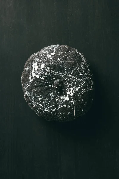 Vista superior de calabaza negra con salpicaduras de pintura blanca sobre fondo oscuro de halloween - foto de stock