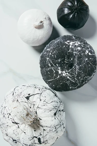 Top view of decorative halloween black and white pumpkins with paint splatters — Stock Photo