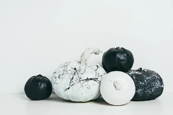 Calabazas decorativas en blanco y negro con salpicaduras de pintura para fiesta de halloween - foto de stock