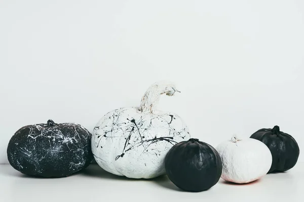 Espantosas calabazas decorativas en blanco y negro con salpicaduras de pintura para la fiesta tradicional de halloween - foto de stock