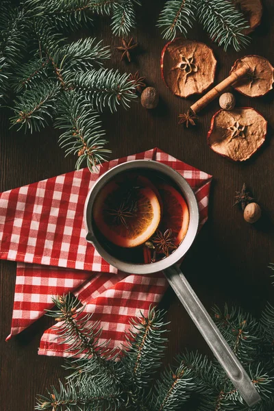 Vista superior del vino tradicional de Navidad caliente especiado sobre fondo de madera con rodajas de manzana seca y ramas de pino - foto de stock