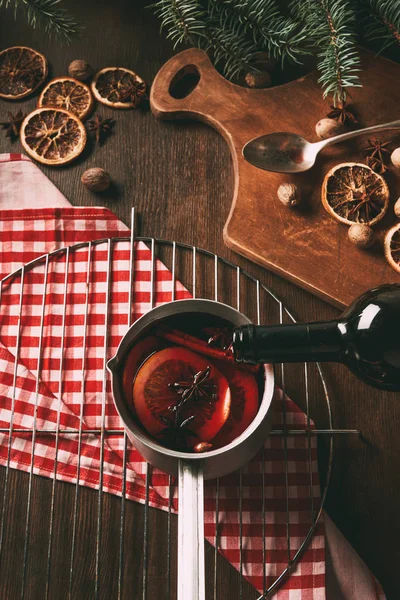 Vino rosso versato in casseruola per fare il vino brulè di Natale con spezie — Foto stock