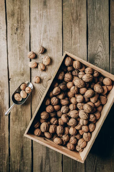 Верхний вид вкусных здоровых грецких орехов в коробке на деревянный стол — стоковое фото