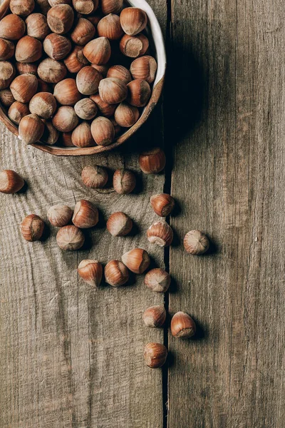 Top view of tasty healthy hazelnuts in bowl on wooden table — Stock Photo