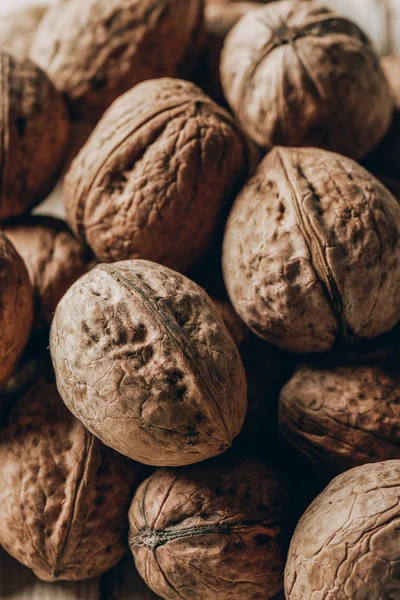 Nahaufnahme eines Haufens roher reifer Walnüsse auf einem Holztisch — Stockfoto