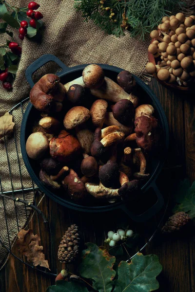 Draufsicht auf frische essbare Pilze in der Pfanne auf Holztisch — Stockfoto