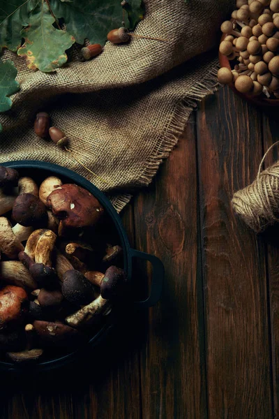 Top view of fresh raw natural mushrooms, rope and sackcloth on wooden table — Stock Photo