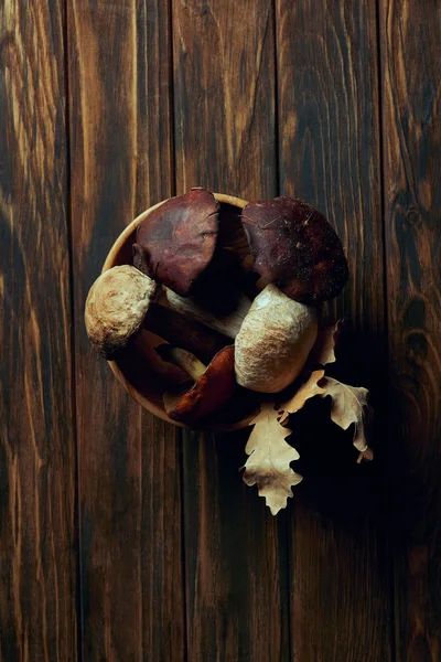 Top view of fresh raw delicious mushrooms in bowl on wooden table — Stock Photo