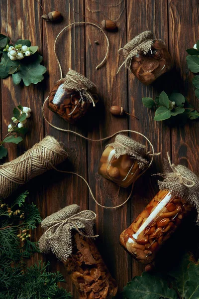 Vue de dessus de délicieux champignons marinés et corde sur table en bois — Photo de stock