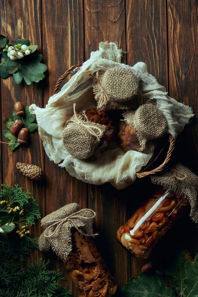 Vista superior de deliciosos cogumelos em conserva na cesta na mesa de madeira — Fotografia de Stock