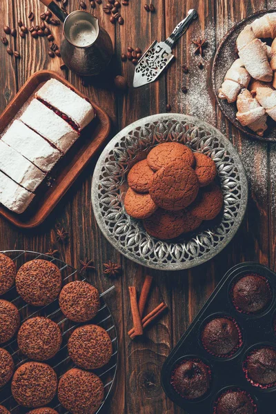 Вид на вкусные выпеченные сладости на тарелках и подносах в пекарне — Stock Photo