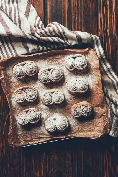 Vista superior de las deliciosas galletas horneadas caseras con azúcar en polvo en bandeja en la panadería - foto de stock
