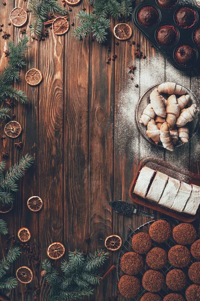 Vista superior de las deliciosas galletas horneadas, galletas y magdalenas en la mesa de madera, concepto de Navidad - foto de stock