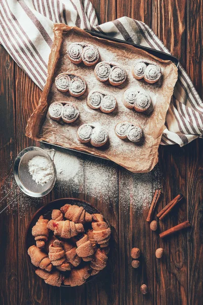 Vue surélevée de délicieux biscuits cuits sur plaque et plateau dans la boulangerie — Photo de stock