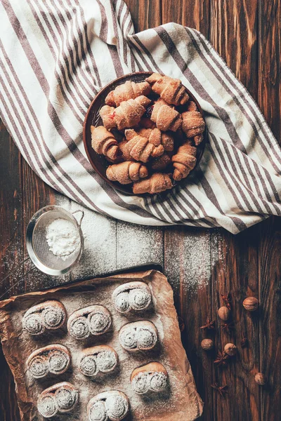 Blick von oben auf leckere gebackene Plätzchen auf Teller und Blech in der Bäckerei — Stockfoto