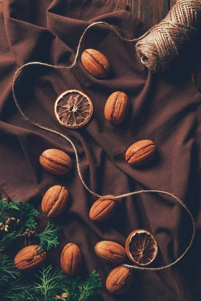 Vista superior de las deliciosas galletas horneadas y carrete de hilo en mantel en panadería - foto de stock