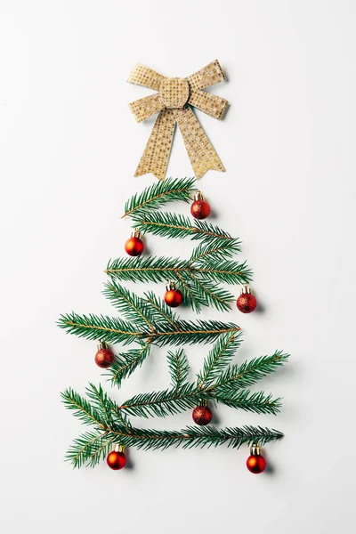 Vista superior de la rama de pino verde decorada como árbol de Navidad festivo con arco sobre fondo blanco — Stock Photo