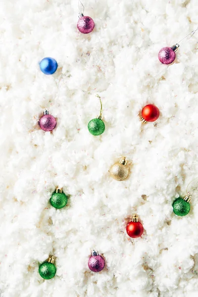 Vista superior de juguetes de Navidad coloridos sobre fondo de lana de algodón blanco - foto de stock