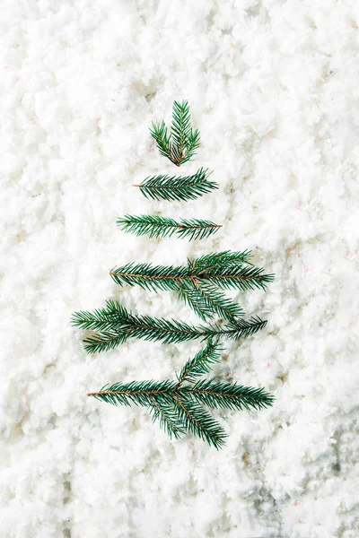 Vue de dessus des branches de pin vert disposées sur fond de laine de coton blanc — Photo de stock