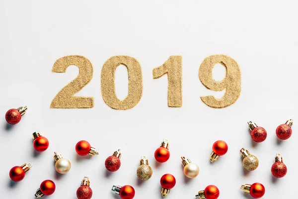 Top view of 2019 year golden sign and christmas balls on white background — Stock Photo