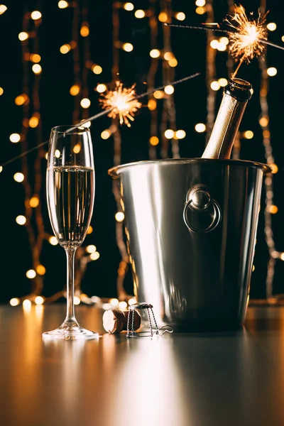 Champagne with bengal lights on garland light background, christmas concept — Stock Photo