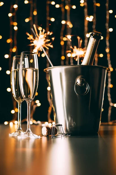 Champán con destellos de fiesta sobre fondo claro guirnalda, concepto de Navidad - foto de stock