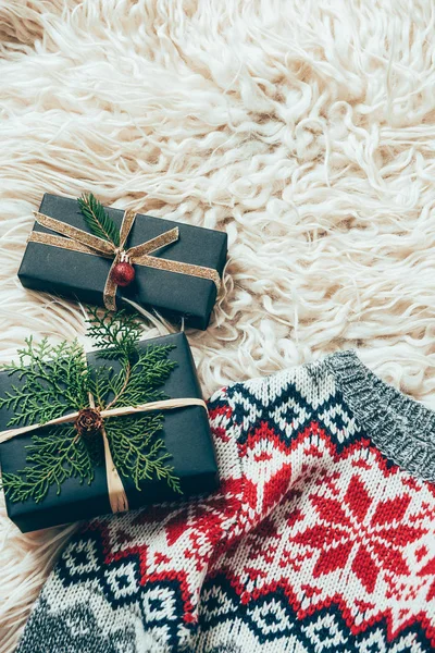 Top view of wrapped christmas presents and winter sweater on woolen backdrop — Stock Photo