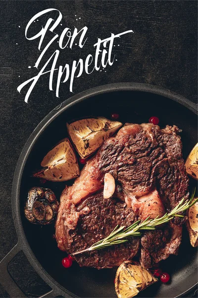 Draufsicht auf gebratenes Steak mit Zitronen und Beeren auf Pfanne in der Küche, Appetitinschrift — Stockfoto