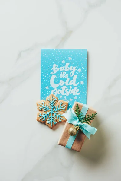 Сверху вид на рождество настоящее, снежинка печенье и поздравительная открытка с надписью 
