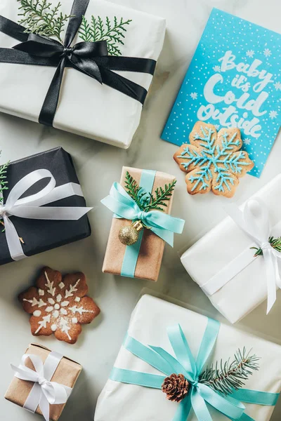 Vista superior de los regalos de Navidad, galletas de copo de nieve y tarjeta de felicitación con letras 