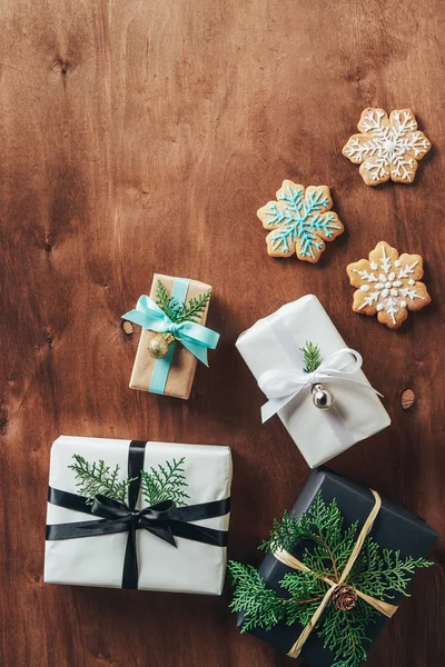 Вид зверху різдвяні подарункові коробки та печиво зі сніжинки на дерев'яному фоні — стокове фото
