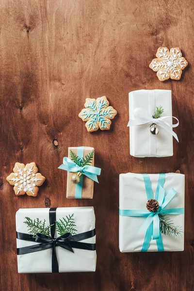 Vue du dessus des coffrets cadeaux et des biscuits de Noël avec glaçage sur fond en bois — Photo de stock