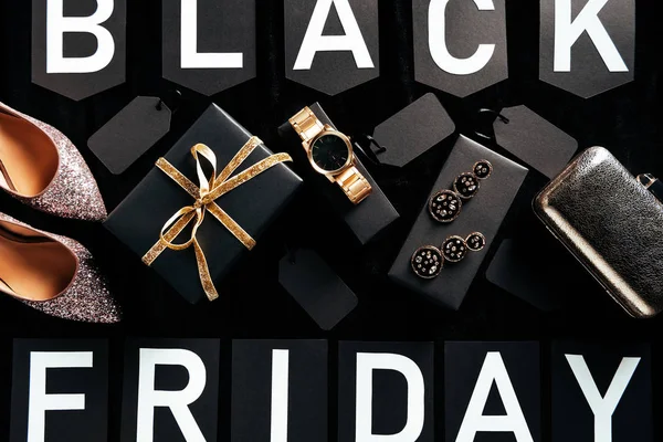 Flat lay with feminine shoes, jewelry and purse with blank price tags on black background, black friday concept — Stock Photo