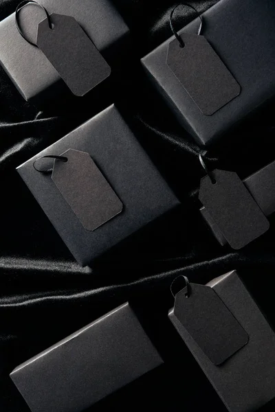Flache Lage mit Schachteln und unbeschriebenen Preisschildern auf schwarzem Hintergrund, Black-Friday-Konzept — Stockfoto