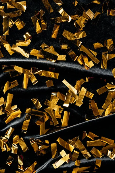 Full frame of golden confetti on black backdrop — Stock Photo