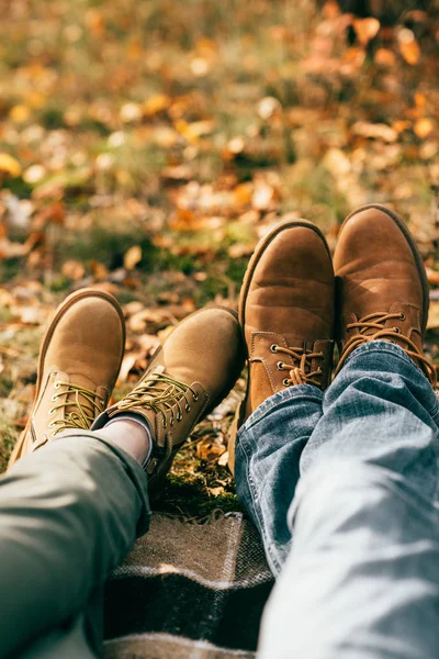 Point de vue de la caméra sur deux paires de bottes orange dans un beau feuillage en automne — Photo de stock