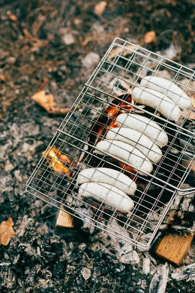 Blick von oben auf die Würstchenreihe auf dem Grillrost über dem Feuer — Stockfoto