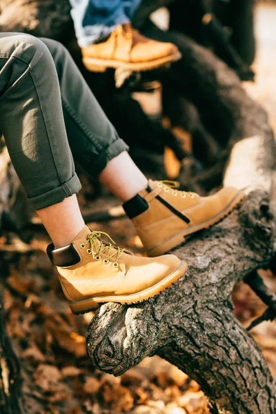 Person wearing orange boots on autumn foliage background — Stock Photo