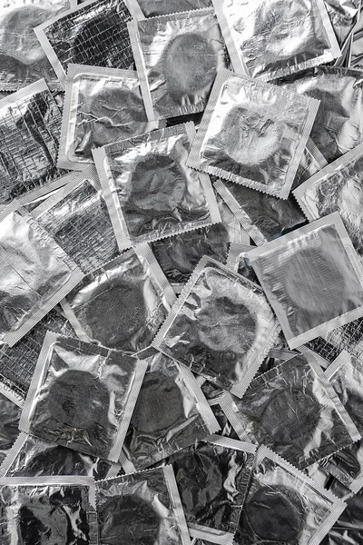 Верхний вид фона с кучей серебряных презервативов — стоковое фото