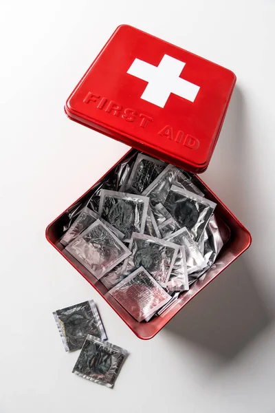 Vista superior da caixa vermelha kit de primeiros socorros com preservativos de prata isolado no branco — Fotografia de Stock