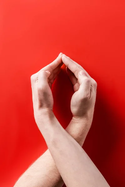 Mãos masculinas mostrando ajuda sinal de consciência no fundo vermelho — Fotografia de Stock