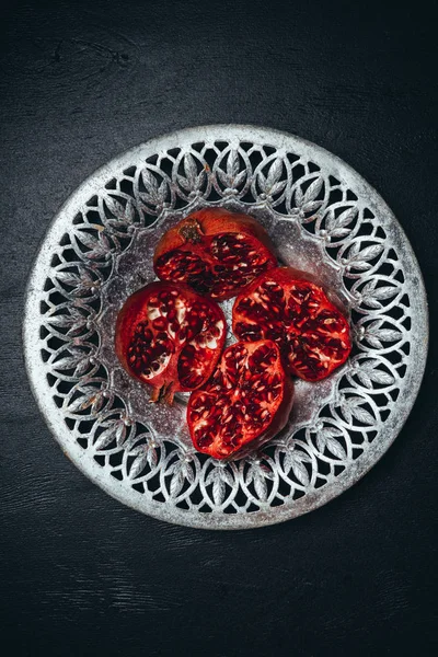 Top view of fresh cut garnets in metal bowl on black surface — Stock Photo