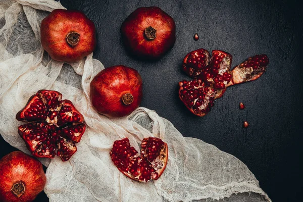 Deitado plano com gaze e arranjo granadas frescas em mesa preta — Fotografia de Stock